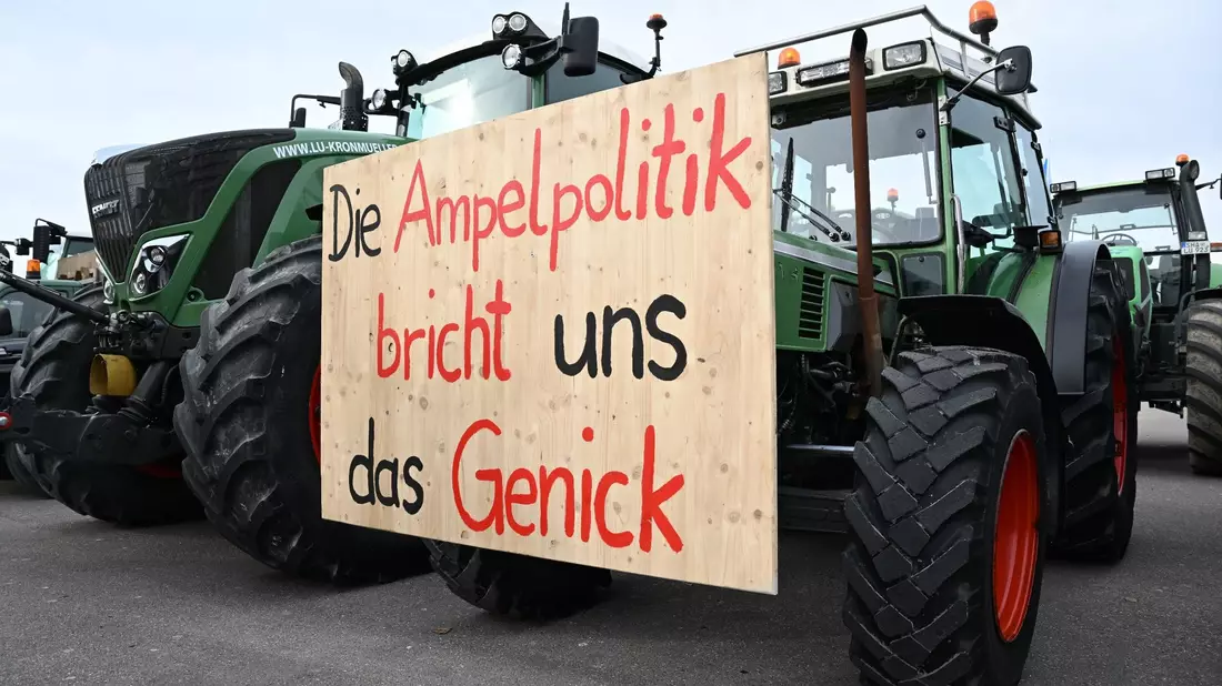Mit Traktoren und einem Transparent mit der Aufschrift: «Die Ampelpolitik bricht uns das Genick» demonstrieren Landwirte auf dem Cannstatter Wasen gegen die Agrarpoltik der Bundesregierung. - Bild: Bernd Weißbrod/dpa