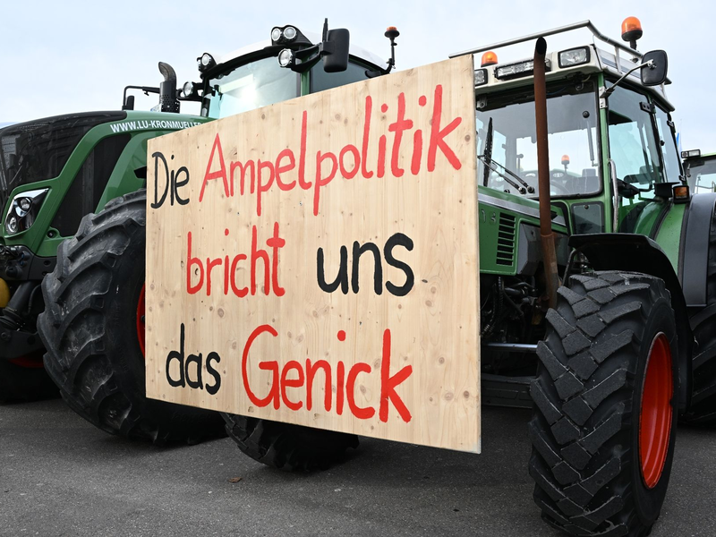 Mit Traktoren und einem Transparent mit der Aufschrift: «Die Ampelpolitik bricht uns das Genick» demonstrieren Landwirte auf dem Cannstatter Wasen gegen die Agrarpoltik der Bundesregierung. - Foto: Bernd Weißbrod/dpa