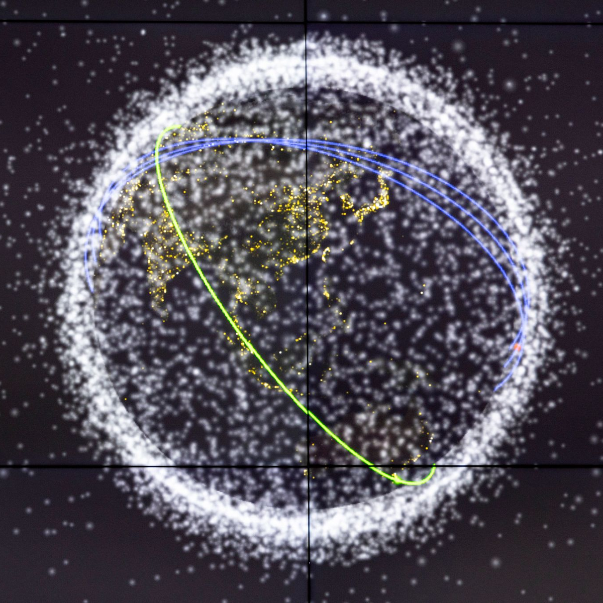 Auf einem Monitor wird die Flugbahn eines ausrangierten Batteriepakets der ISS um die Erde angezeigt. - Foto: Christoph Reichwein/dpa