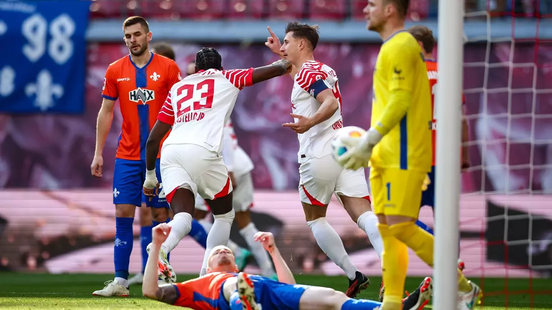 Die Leipziger Spieler jubeln nach dem Eigentor von Darmstadts Thomas Isherwood zum 1:0. - Bild: Jan Woitas/dpa