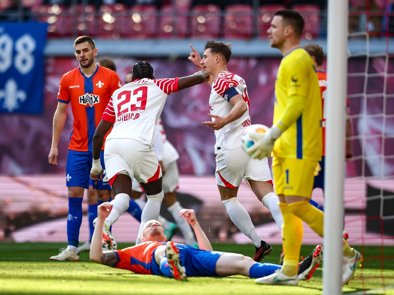 Die Leipziger Spieler jubeln nach dem Eigentor von Darmstadts Thomas Isherwood zum 1:0. - Foto: Jan Woitas/dpa