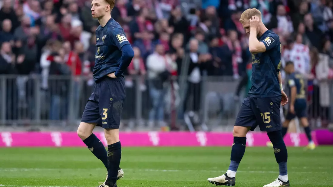 Die Mainzer Sepp van den Berg (l) und Andreas Hanche-Olsen sind nach der Klatsche beim FC Bayern enttäuscht. - Bild: Sven Hoppe/dpa