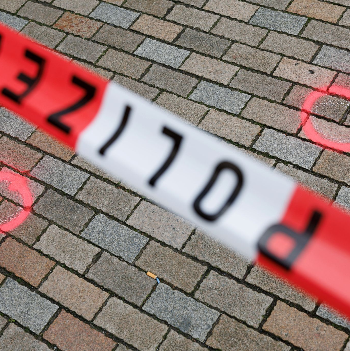 Markierungen der Kriminaltechnik am abgesperrten Tatort. - Foto: Friso Gentsch/dpa