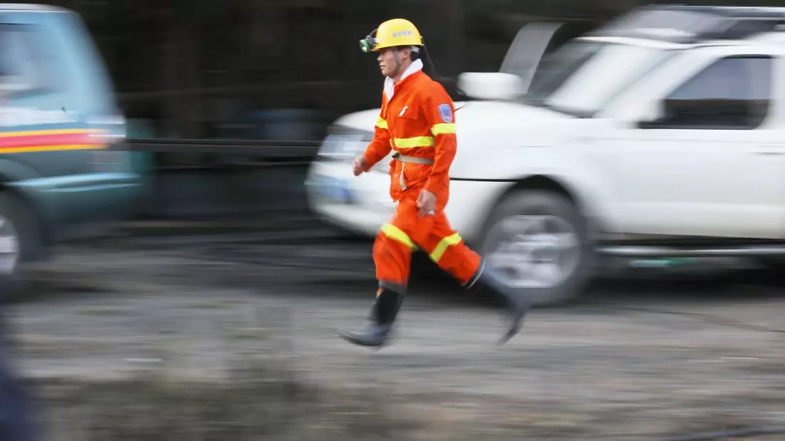 Ein Helfer eines Rettungsdienstes läuft bei einem Einsatz nach einem Grubenunglück. - Bild: Ou Dongqu/XinHua/dpa