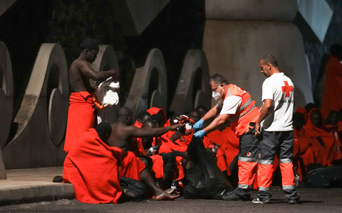 Mitarbeiter des Roten Kreuzes verteilen im November Wasser an Migranten an einer Anlegestelle im Hafen von La Restinga auf der kanarischen Insel El Hierro. - Foto: Humberto Bilbao/AP/dpa