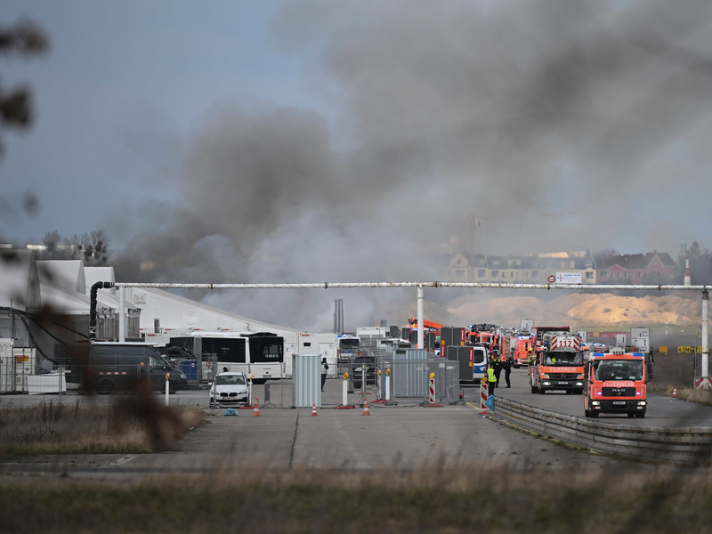 Feuerwehrmänner löschen die letzten Brandstellen in der Flüchtlingsunterkunft am ehemaligen Flughafen Tegel. - Foto: Sebastian Gollnow/dpa