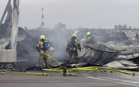 Die Feuerwehr löscht die Brandstelle bei der Flüchtlingsunterkunft am ehemaligen Flughafen Tegel. Die Nachlöscharbeiten sind inzwischen abgeschlossen. - Foto: Carsten Koall/dpa