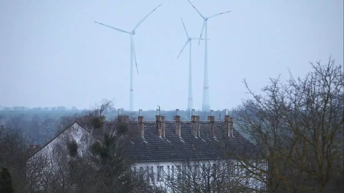 Ein Mehrfamilienhaus mit Windrädern im Hintergrund am 09.03.2024 - Bild: über dts Nachrichtenagentur