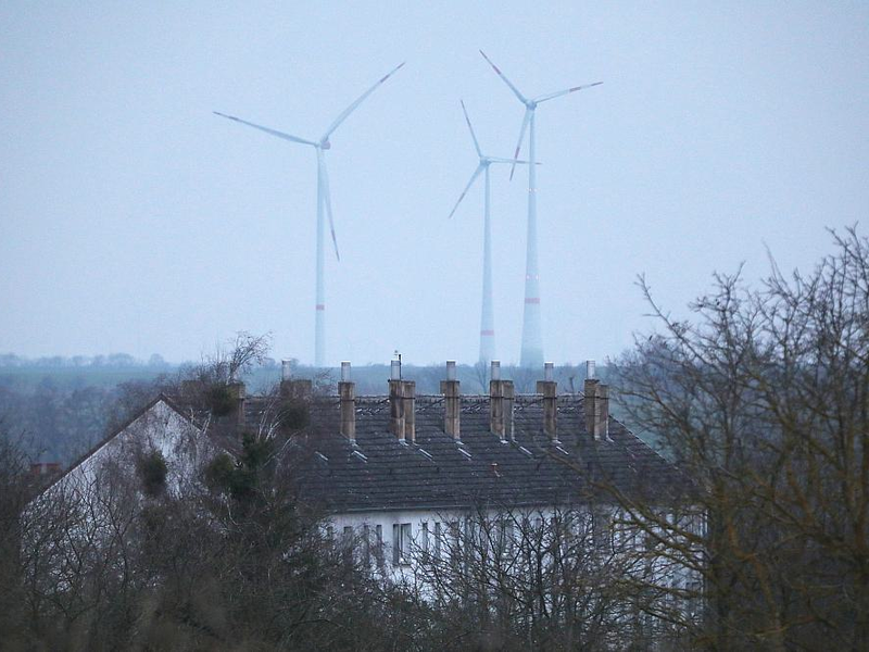 Ein Mehrfamilienhaus mit Windrädern im Hintergrund am 09.03.2024 - Foto: über dts Nachrichtenagentur