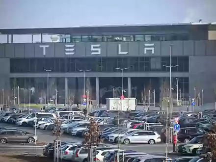 Eingang zum Tesla-Werk in Grünheide.  Die Einwohner von Grünheide hatten sich vor drei Wochen in einem Bürgerentscheid gegen die Rodung von 100 Hektar Wald und damit die Erweiterung der Fläche von Tesla ausgesprochen. - Foto: Sebastian Christoph Gollnow/dpa