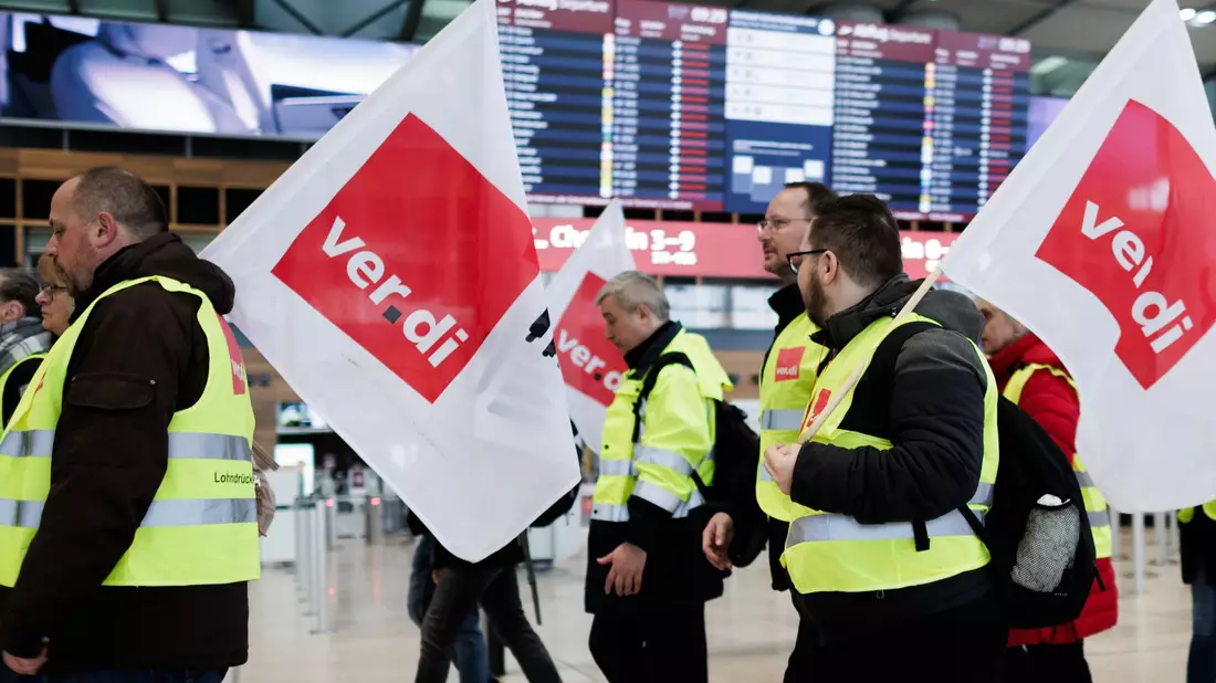 Mitarbeiter des Luftsicherheitspersonals demonstrieren in der Abflughalle im Terminal 1 des Flughafens BER. - Bild: Carsten Koall/dpa
