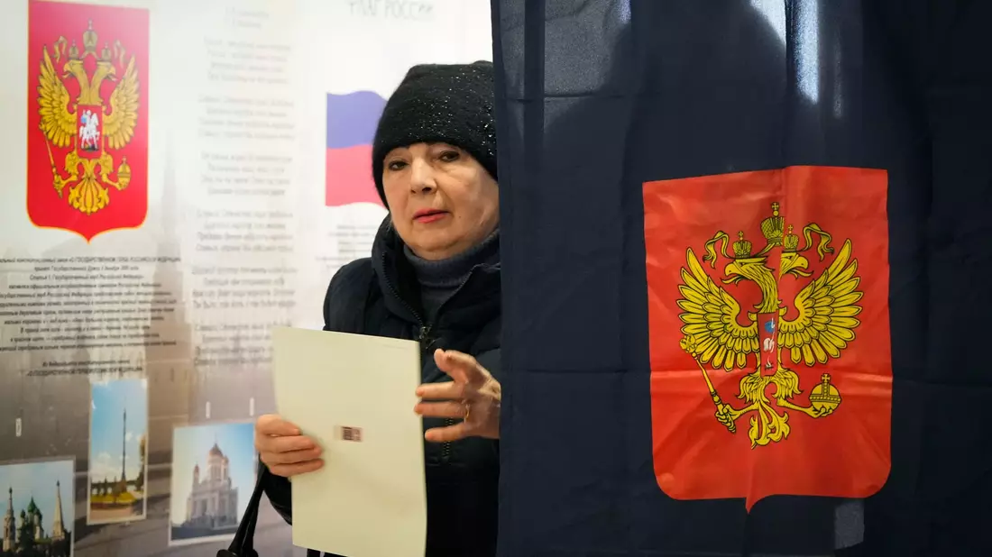 Eine Frau verlässt eine Wahlkabine in einem Wahllokal während der Präsidentschaftswahlen. - Bild: Dmitri Lovetsky/AP