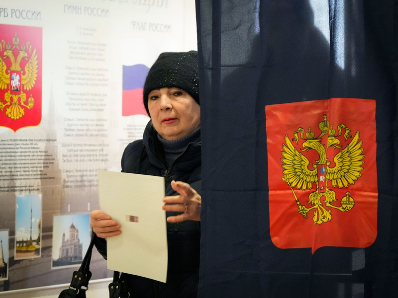 Eine Frau verlässt eine Wahlkabine in einem Wahllokal während der Präsidentschaftswahlen. - Foto: Dmitri Lovetsky/AP