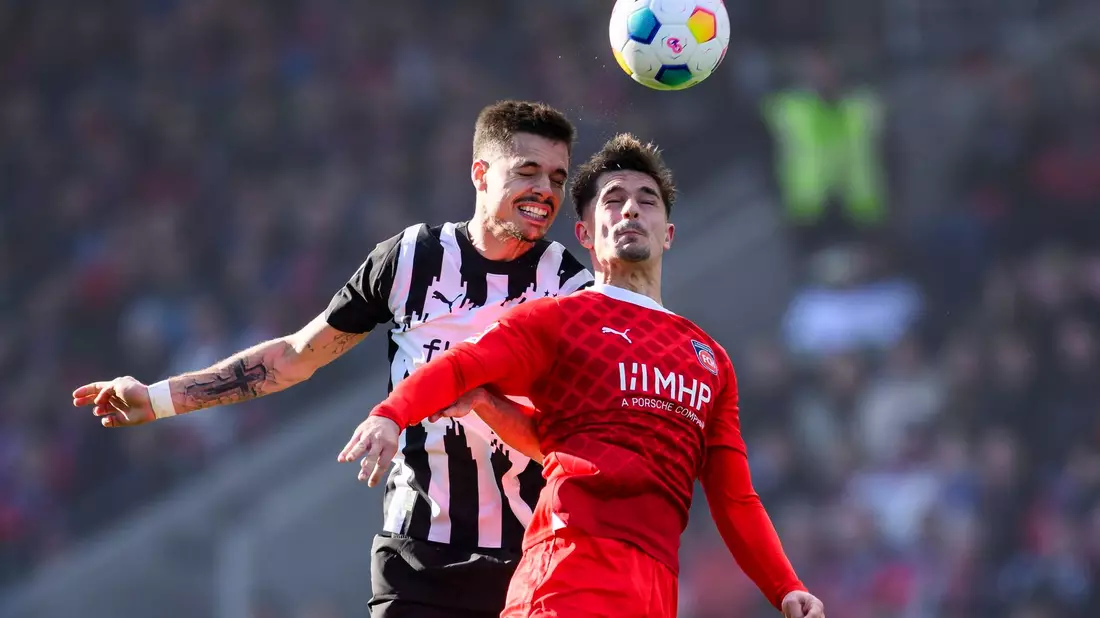 Heidenheims Jan-Niklas Beste (r) im Zweikampf mit Rocco Reitz. - Bild: Tom Weller/dpa