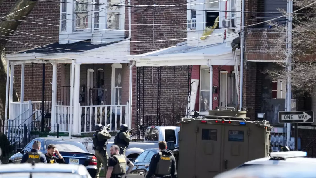 Polizisten umstellen das Haus in Trenton, in dem sich der mutmaßliche Täter mit seinen Geiseln verschanzt hat. - Bild: Matt Rourke/AP/dpa