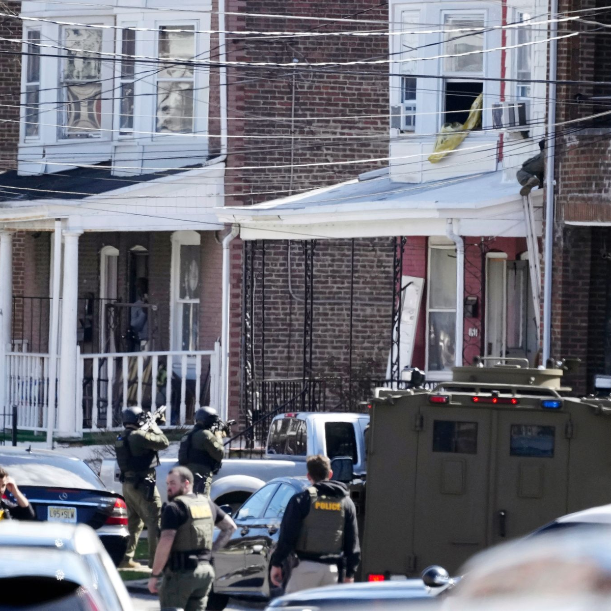 Polizisten umstellen das Haus in Trenton, in dem sich der mutmaßliche Täter mit seinen Geiseln verschanzt hat. - Foto: Matt Rourke/AP/dpa