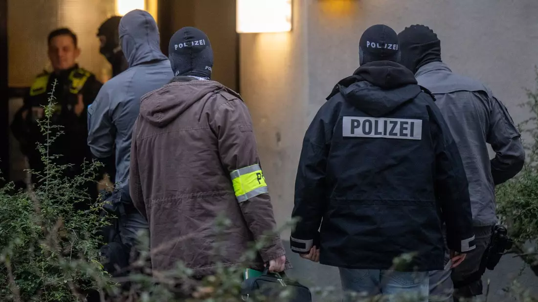 Maskierte Polizisten dursuchen das Wohnhaus der früheren RAF-Terroristin Daniela Klette in Berlin-Kreuzberg. - Bild: Monika Skolimowska/dpa