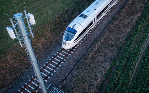Ein Testzug der Deutschen Bahn fährt an einer der Antennenmasten für das 5G-Bahnprojekt vorbei. - Foto: Jens Büttner/dpa