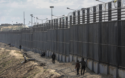 Palästinenser stehen nahe der Grenze zwischen dem Gazastreifen und Ägypten. - Foto: Mohammed Talatene/dpa