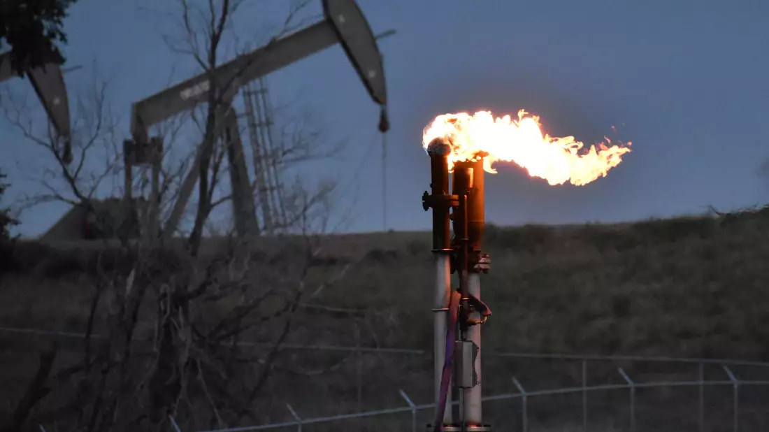 Eine Fackel zur Verbrennung von Methan aus der Ölförderung. Das Treibhausgas entsteht unter anderem in der Öl-, Gas- und Kohleindustrie. - Bild: Matthew Brown/AP/dpa