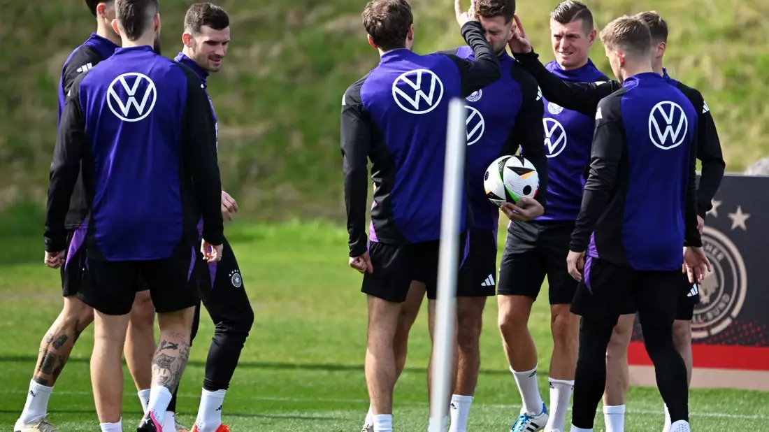 Nationalspieler stehen vor Beginn einer Spielform im Training zusammen. - Bild: Arne Dedert/dpa