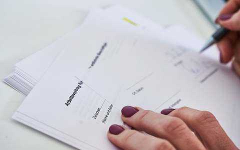 Eine Frau unterschreibt einen Arbeitsvertrag. - Foto: Annette Riedl/dpa