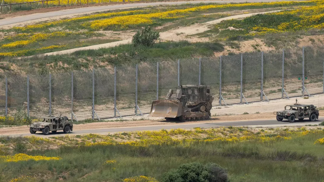 Ein Planierraupe der israelischen Armee ist in der Nähe der Grenze zum Gazastreifen zu sehen: Israel errichtet Berichten zufolge eine Kontrollstation. - Bild: Ohad Zwigenberg/AP/dpa