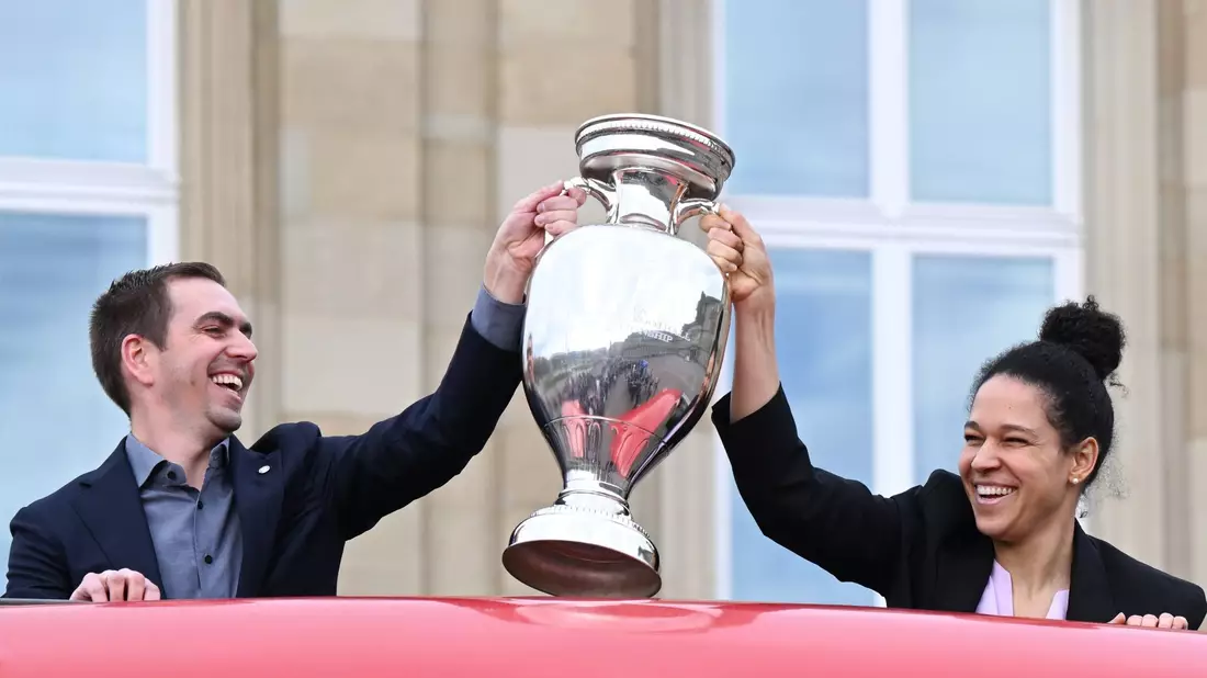 Philipp Lahm, Turnierdirektor der Fußball-Europameisterschaft, hält zusammen mit der früheren Fußball Nationalspielerin Celia Sasic den EM-Pokal hoch. - Bild: Bernd Weißbrod/dpa