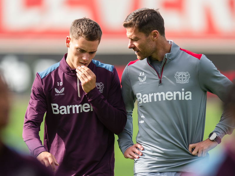 Leverkusens Trainer Xabi Alonso (r) im Gespräch mit Florian Wirtz. - Foto: Marius Becker/dpa