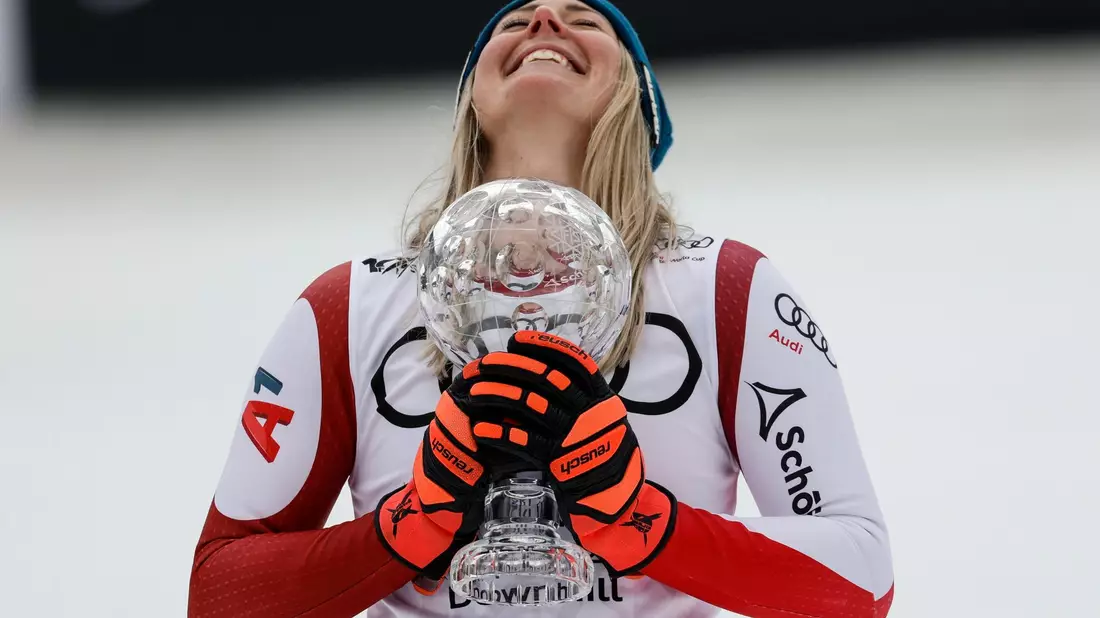 Nach ihrem Abfahrtssieg jubelt Cornelia Hütter mit der Kristallkugel-Trophäe. - Bild: Alessandro Trovati/AP/dpa