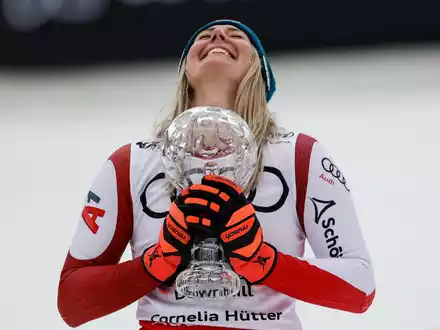 Nach ihrem Abfahrtssieg jubelt Cornelia Hütter mit der Kristallkugel-Trophäe. - Foto: Alessandro Trovati/AP/dpa