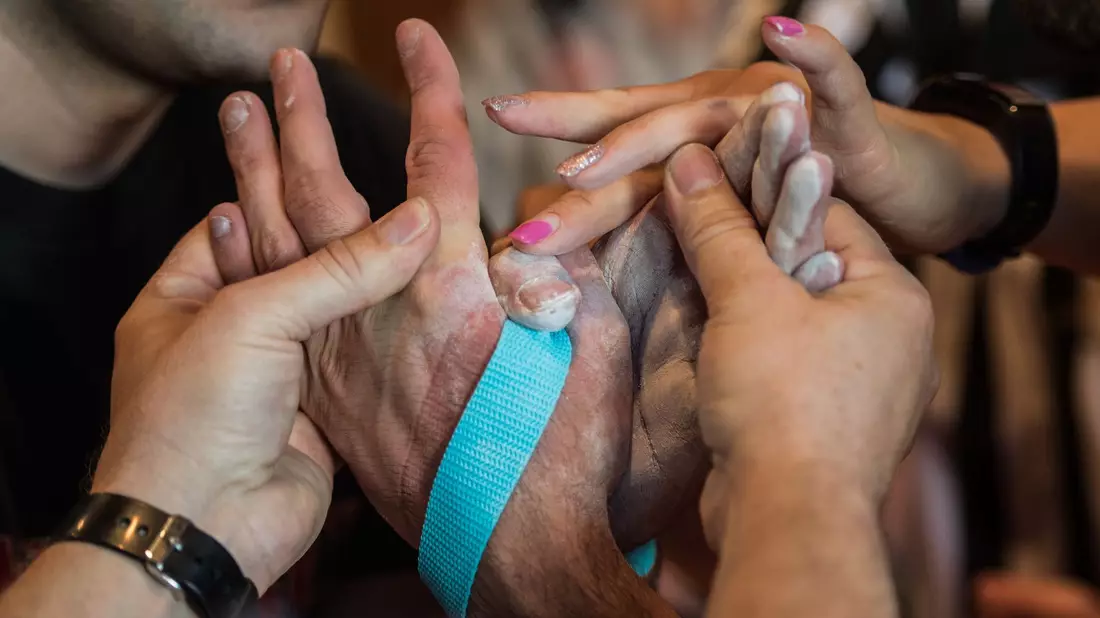 Die beiden Schiedsrichter binden bei den Deutschen Meisterschaften im Armwrestling die Hände der Athleten mit einem Gurt zusammen, um ein erneutes Abrutschen zu verhindern. - Bild: Andreas Arnold/dpa