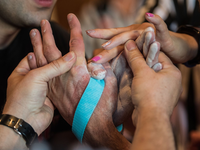 Die beiden Schiedsrichter binden bei den Deutschen Meisterschaften im Armwrestling die Hände der Athleten mit einem Gurt zusammen, um ein erneutes Abrutschen zu verhindern. - Foto: Andreas Arnold/dpa