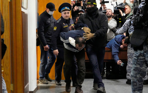 Ein Tatverdächtiger wird von Polizisten und FSB-Beamten im Basmanny-Bezirksgericht eskortiert. - Foto: Alexander Zemlianichenko/AP