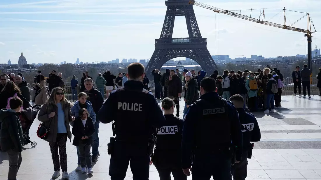 Polizisten patrouillieren auf dem Trocadero-Platz unweit des Eiffelturms. - Bild: Michel Euler/AP