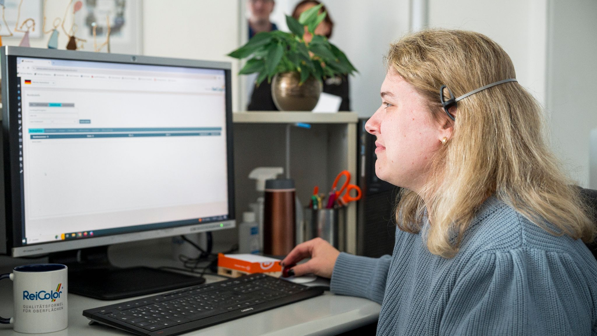 Eva Lenz arbeitet am Empfang der ReiColor Chemie-GmbH. - Foto: Daniel Vogl/dpa