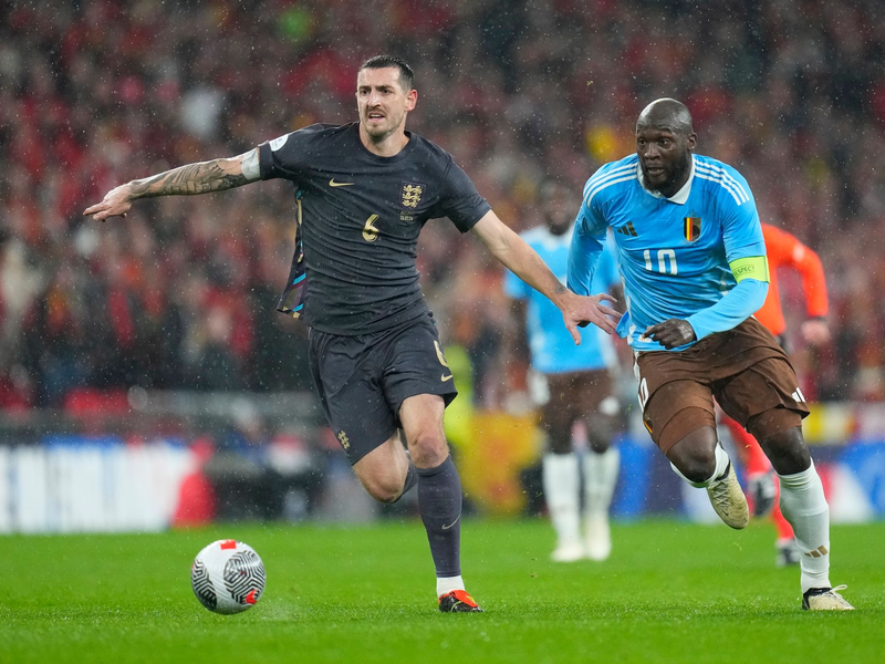 Lewis Dunk (l) aus England im Laufduelle mit dem Belgier Romelu Lukaku. - Foto: Kirsty Wigglesworth/AP/dpa