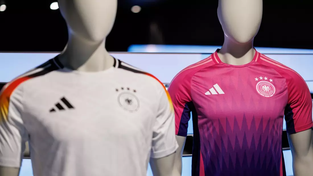 Wurde kontrovers diskutiert: die Farbwahl des neuen Pink und lilafarbenen Auswärtstrikots der deutschen Fußballnationalmannschaft (r). - Bild: Daniel Karmann/dpa