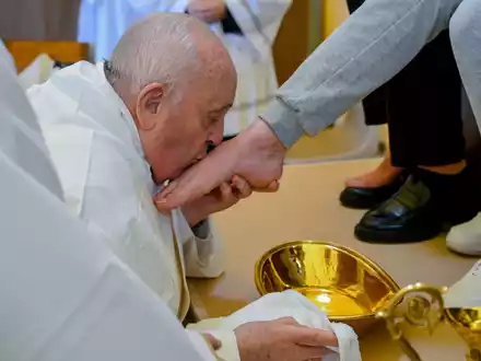 Papst Franziskus küsst den Fuß von einer weiblichen Insassin des Rebibbia-Gefängnisses. - Foto: Vatican Media/AP/dpa