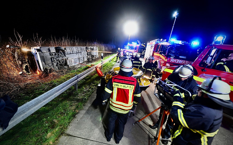 Einsatzkräfte der Feuerwehr arbeiten an einer Unfallstelle auf der Autobahn 44 (A44) an einem verunfallten Bus. - Foto: Daniel Schröder/dpa