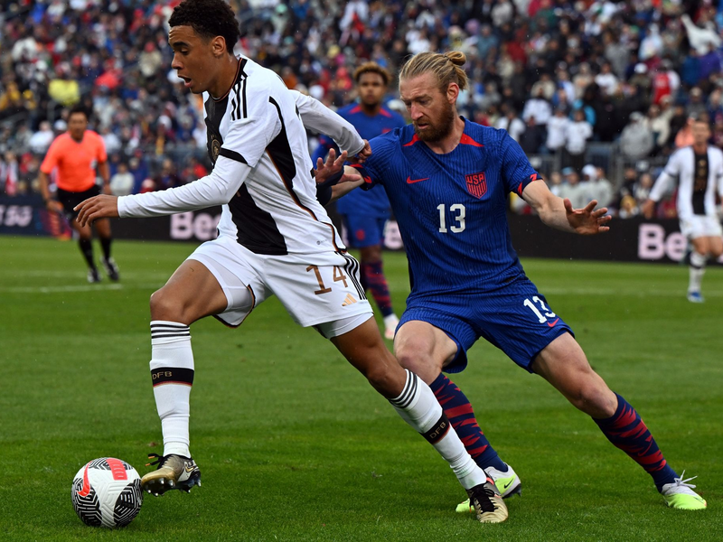Deutschlands Jamal Musiala und der US-Amerikaner Tim Reamm liefern sich einen Zweikampf um den Ball. - Foto: Federico Gambarini/dpa/Archivbild