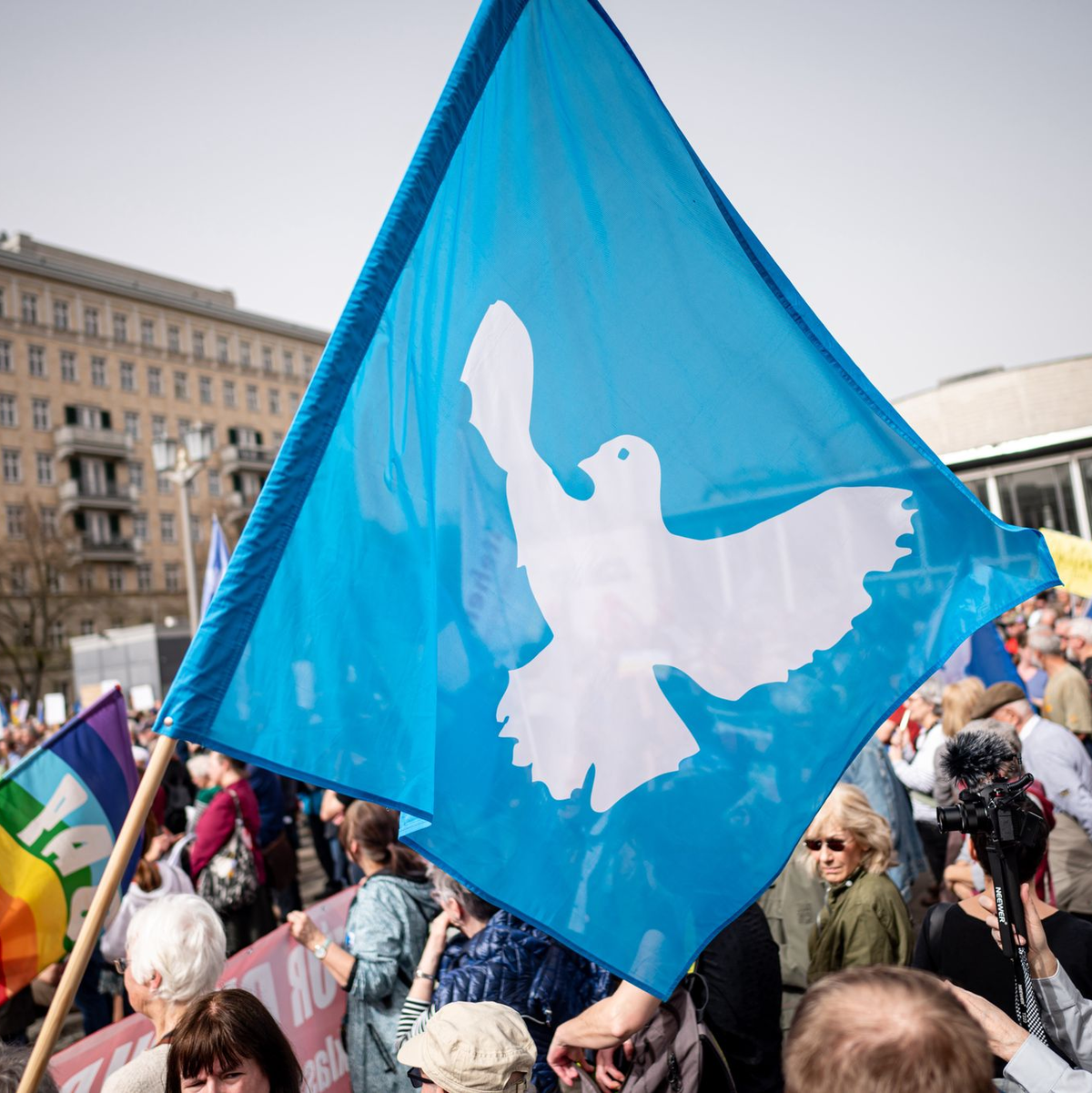Eine Flagge mit der Friedenstaube ist auf dem traditionellen Ostermarsch in Berlin zu sehen. - Foto: Fabian Sommer/dpa