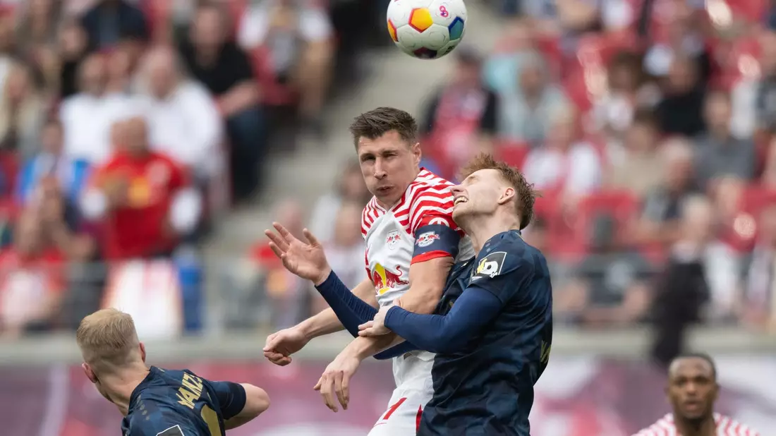 Leipzigs Willi Orban (M) im Kopfball-Duell mit dem Mainzer Sepp van den Berg. - Bild: Hendrik Schmidt/dpa
