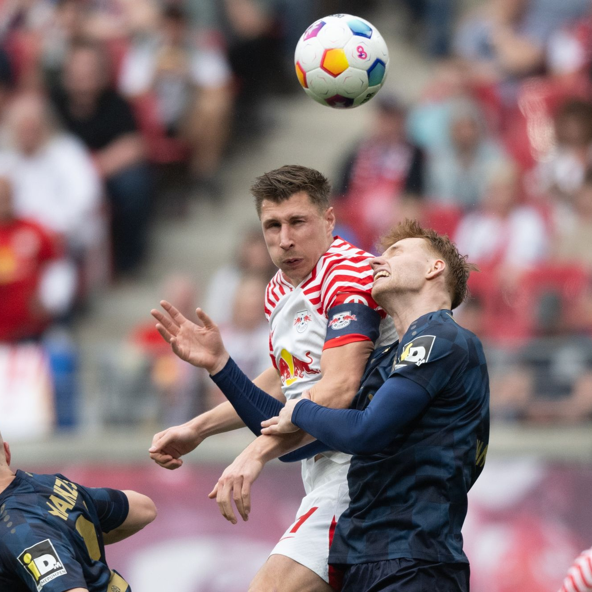 Leipzigs Willi Orban (M) im Kopfball-Duell mit dem Mainzer Sepp van den Berg. - Foto: Hendrik Schmidt/dpa
