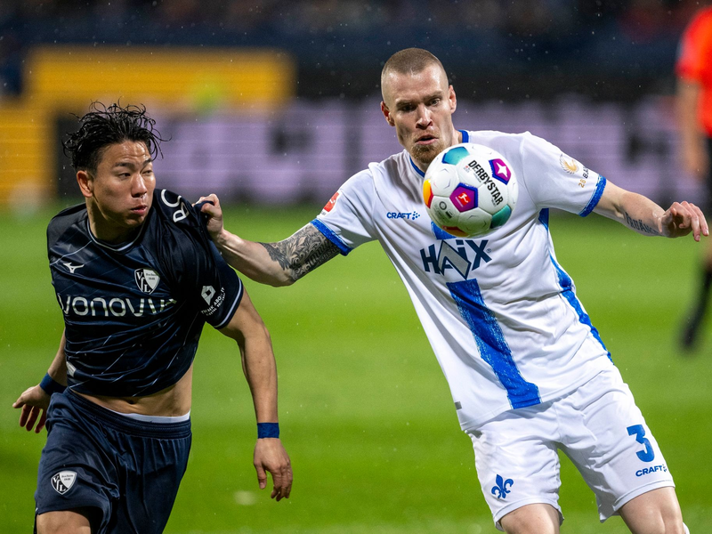 Darmstadts Thomas Isherwood (r) im Zweikampf mit dem Bochumer Takuma Asano. - Foto: David Inderlied/dpa