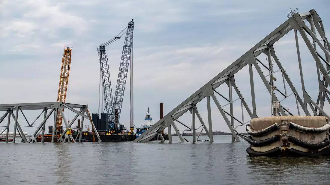 Die Bergungsteams trennen mit einem exothermen Schneidbrenner systematisch Teile der Stahlbrücke ab. - Bild: Petty Officer 3rd Class Kimberly/U.S. Coast Guard/AP/dpa