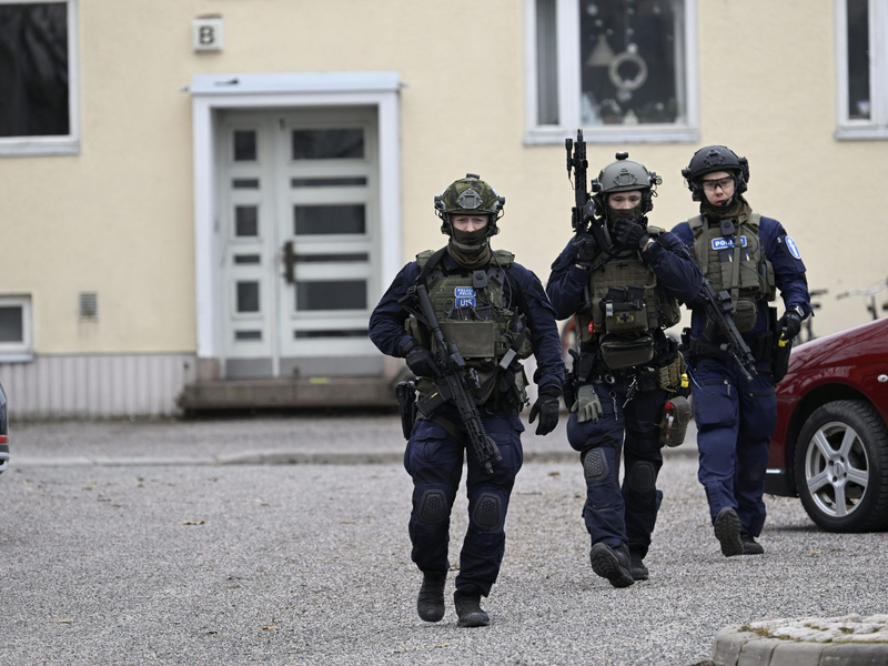 Bewaffnete Polizisten gehen in der Nähe der Viertola-Schule. Bei dem Vorfall an einer Grundschule in der finnischen Stadt Vantaa nördlich von Helsinki sind Kinder verletzt worden. Ein zwölf Jahre altes Kind stirbt. - Foto: Markku Ulander/Lehtikuva/dpa