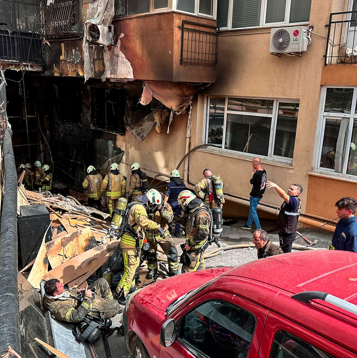 Feuerwehrleute sind nach dem Brand in einem Nachtclub im Einsatz. - Foto: Uncredited/IHA/AP/dpa