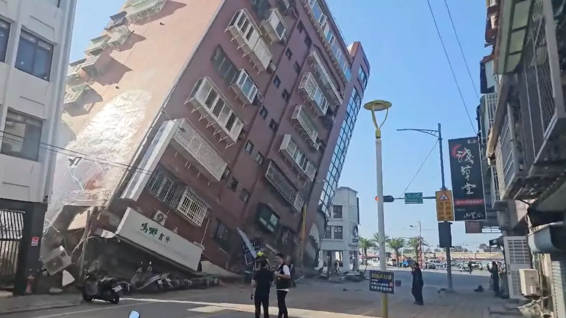 Anwohner retten ein Kind aus einem teilweise eingestürzten Gebäude in Hualien im Osten Taiwans. - Bild: -/TVBS via AP/dpa