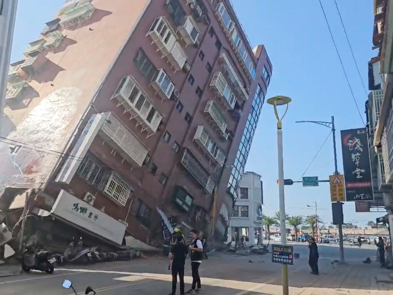 Anwohner retten ein Kind aus einem teilweise eingestürzten Gebäude in Hualien im Osten Taiwans. - Foto: -/TVBS via AP/dpa